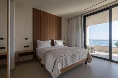 a bedroom with a large bed and a large window at Gemini Villas Chania - Calma & Siesta in Maleme
