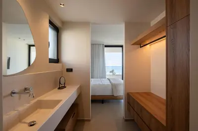a bathroom with a large sink and a bedroom at Gemini Villas Chania - Calma & Siesta in Maleme