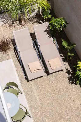 two chairs and tables on a patio with plants at See2sea Cozy Apartments in Kolymvari
