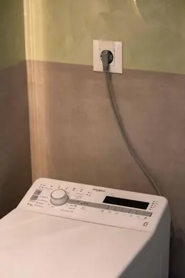 a washing machine with a hose hooked up to a wall at See2sea Cozy Apartments in Kolymvari