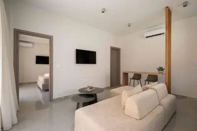 a living room with a couch and a bedroom at See2sea Cozy Apartments in Kolymvari