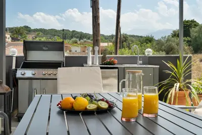 a table with a plate of fruit and two glasses of orange juice at Echoes of Prinos in Metókhion Yianítsari
