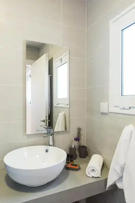 a bathroom with a large white sink and a mirror at Falasarna Seafront House I 50m to the Beach in Kavoúsion