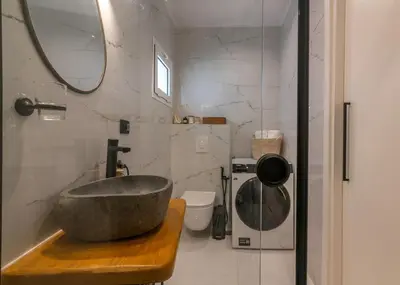 a bathroom with a stone sink and a mirror at SUITEArT 1 Stylish apartment in Chania Town