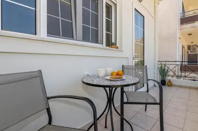 a table with two chairs and a table with oranges on it at SUITEArT 1 Stylish apartment in Chania Town