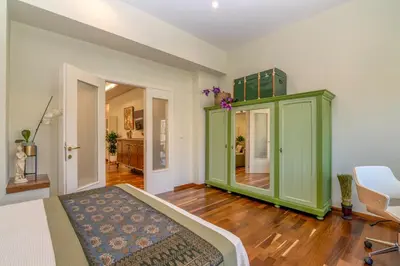 a bedroom with a green cabinet and a chair at SUITEArT 2 Exceptional apartment in Chania Town