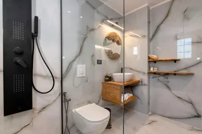 a bathroom with a toilet and a glass shower at SUITEArT 2 Exceptional apartment in Chania Town