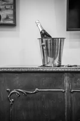 a bottle of champagne in a bucket on a dresser at SUITEArT 2 Exceptional apartment in Chania Town