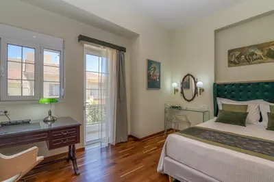 a bedroom with a bed and a desk and a window at SUITEArT 2 Exceptional apartment in Chania Town
