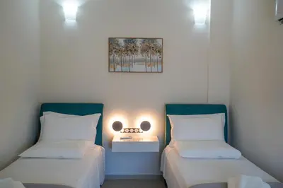 a room with two beds and a picture on the wall at Katakis Afroditi-Athina in Agios Onoufrios
