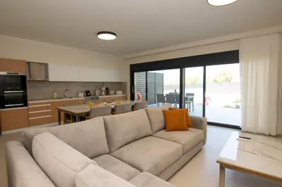 a living room with a couch and a kitchen at Katakis Afroditi-Athina in Agios Onoufrios
