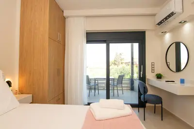 a bedroom with a bed and a table with chairs at Katakis Afroditi-Athina in Agios Onoufrios