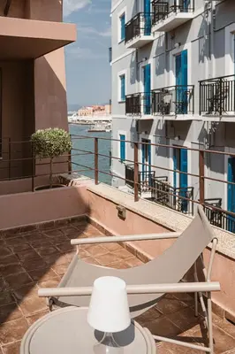 a table and a chair on a balcony with a building at Evrima High End Residence in Chania Town