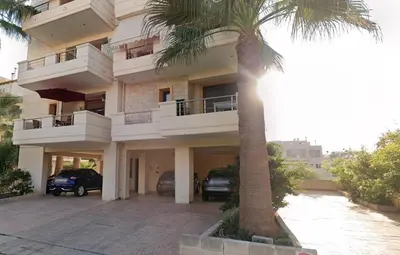 a building with a palm tree in front of it at Light House Chania - 5 Min to Beach and Free Parking in Chania Town