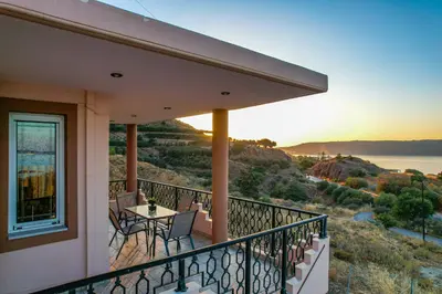 a balcony of a house with a table and chairs at Elysian Bayview Souda Bay Panorama Chania in Zakhariás