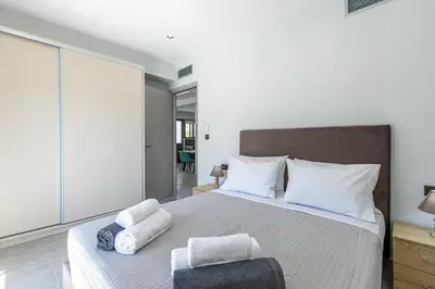 a bedroom with a large bed with towels on it at Neaira Apartments in Vatólakkos