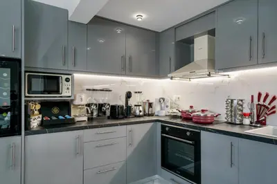 a kitchen with white cabinets and a counter top at New Beachfront villa Six Stars in Chania,close to the beach & amenities in Kamisianá