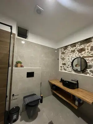 a bathroom with a toilet and a mirror on the wall at Armela in Áyioi Theódhoroi