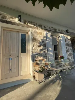 a stone building with a door and a window at Armela in Áyioi Theódhoroi