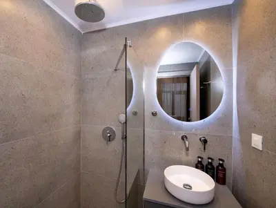 a bathroom with a sink and a shower with a mirror at Alba Boutique Hotel in Chania Town