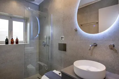 a bathroom with a sink and a shower with a mirror at Alba Boutique Hotel in Chania Town