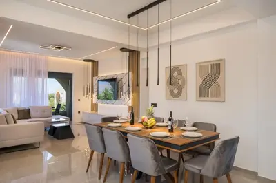 a dining room and living room with a table and chairs at Luna Luxury Living in Tavronitis
