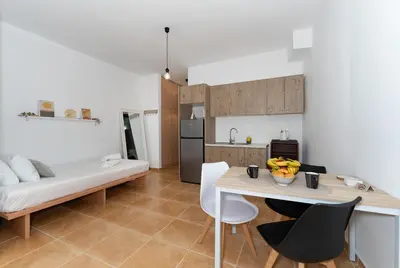 a kitchen and living room with a couch and a table at Kalamaki del mar apartments in Galatás