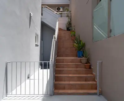 a staircase in a house with wooden stairs and plants at Kalamaki del mar apartments in Galatás