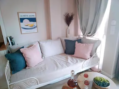 a white couch with pink and blue pillows in a room at RosaMaria's Garden in Kounoupidhianá