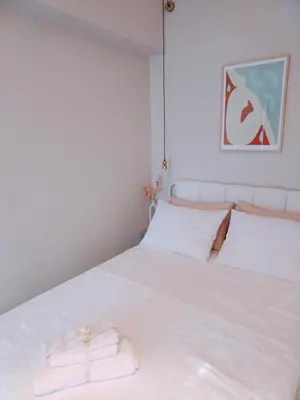a bedroom with a white bed with a towel on it at RosaMaria's Garden in Kounoupidhianá