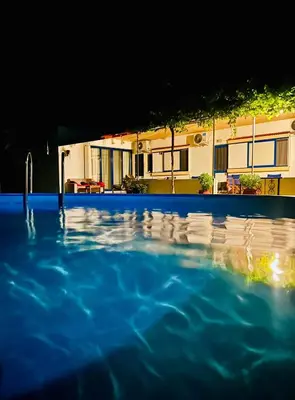 a swimming pool in front of a house at Panos Appartments in Palaiochóra
