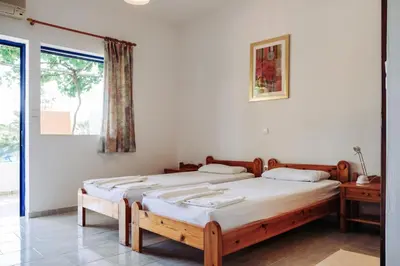 two twin beds in a room with a window at Panos Appartments in Palaiochóra