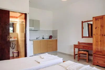 a kitchen with a bed and a sink and a desk at Panos Appartments in Palaiochóra