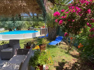 a backyard with a swimming pool and flowers at Panos Appartments in Palaiochóra