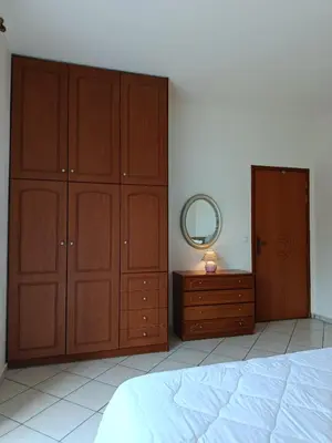 a bedroom with wooden cabinets and a bed and a mirror at By the sea in Chania Town