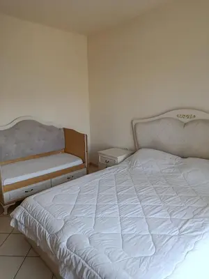 a bedroom with a white bed and a chair at By the sea in Chania Town