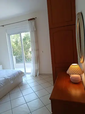a bedroom with a bed and a table with a lamp at By the sea in Chania Town