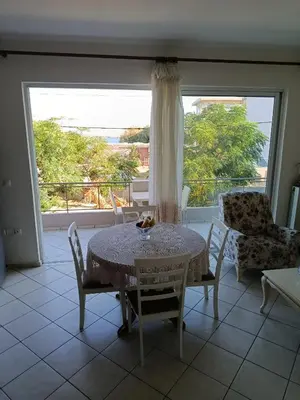 a dining room with a table and chairs and a window at By the sea in Chania Town