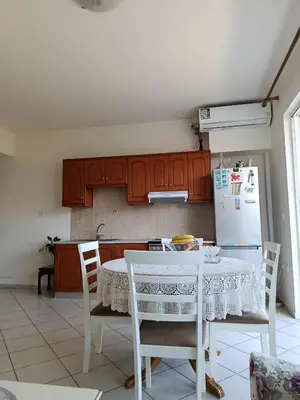a kitchen with a table with chairs and a refrigerator at By the sea in Chania Town