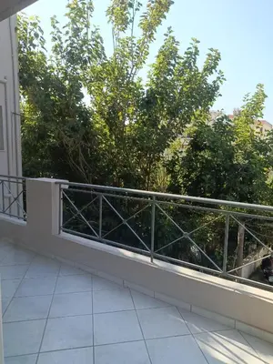 a balcony with a railing with trees in the background at By the sea in Chania Town