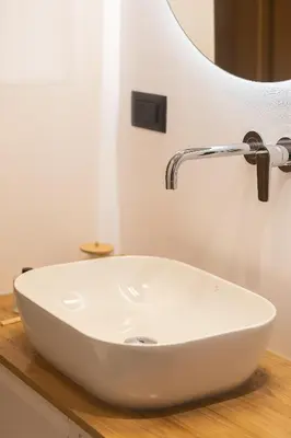 a white sink on a wooden counter in a bathroom at 2BR Central Chania, Steps to Koum Kapi & Old Town in Chania Town