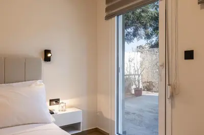 a bedroom with a bed and a sliding glass door at 2BR Central Chania, Steps to Koum Kapi & Old Town in Chania Town