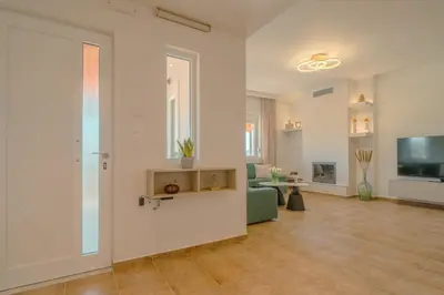 a living room with a couch and a television at Olea Retreat Villa in Yerakianá