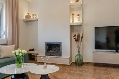 a living room with two tables and a tv at Olea Retreat Villa in Yerakianá