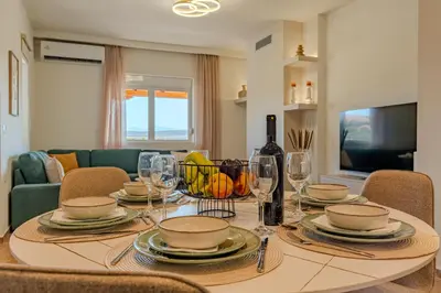 a dining room table with glasses and a bottle of wine at Olea Retreat Villa in Yerakianá