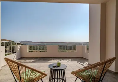 a patio with two chairs and a table on a balcony at Olea Retreat Villa in Yerakianá