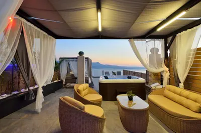 a balcony with chairs and a table and a tub at Villa Ravdoucha in Ravdhoúkha