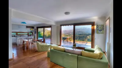 a living room with a green couch and a kitchen at Villa Orgoni in Plataniás