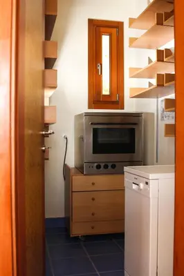 a kitchen with a microwave on a wooden cabinet at Villa Orgoni in Plataniás