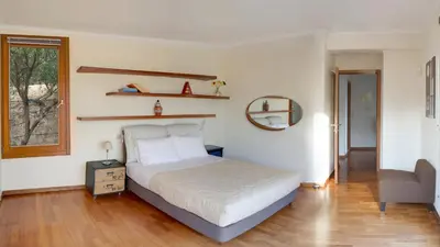 a bedroom with a bed and a chair and a window at Villa Orgoni in Plataniás